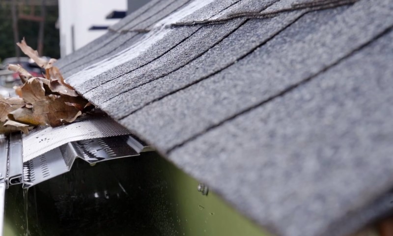 Close-up of a gutter filled with colorful autumn leaves